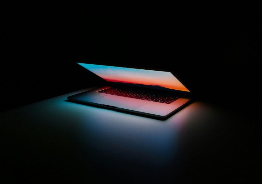 A laptop with a neon wallpaper.